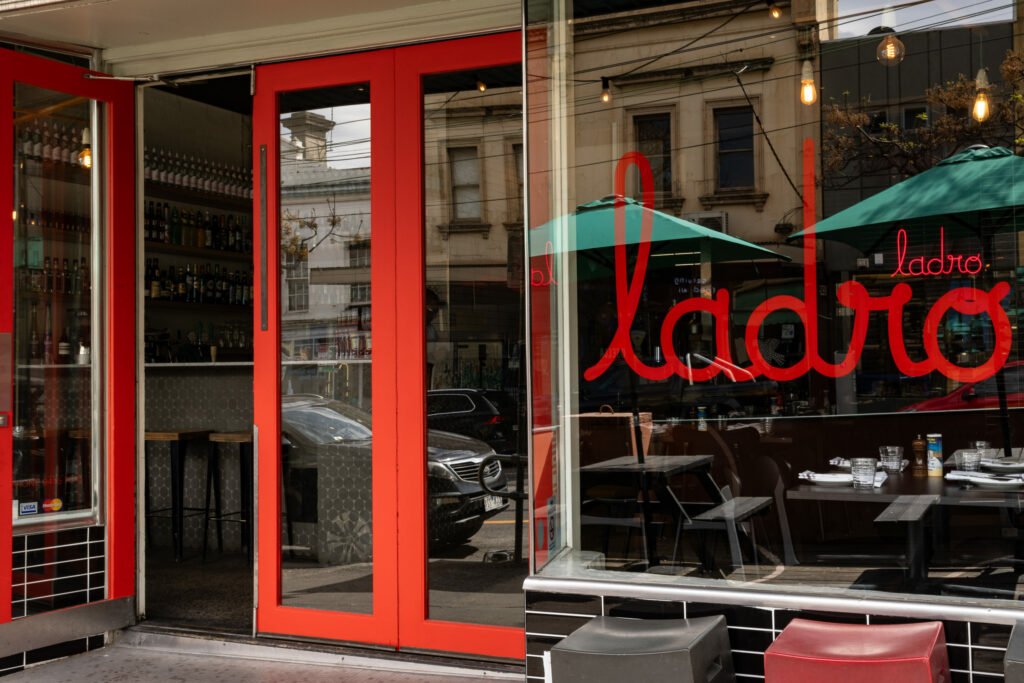 Restaurant entrance with red doors and window seating.