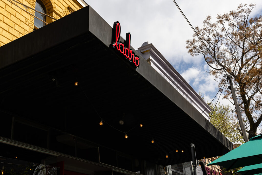 Restaurant exterior with Ladro sign and string lights.