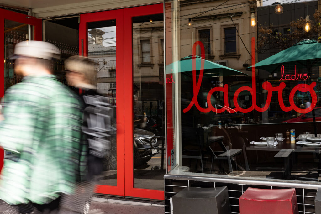 Entrance of restaurant with red doors and sign.
