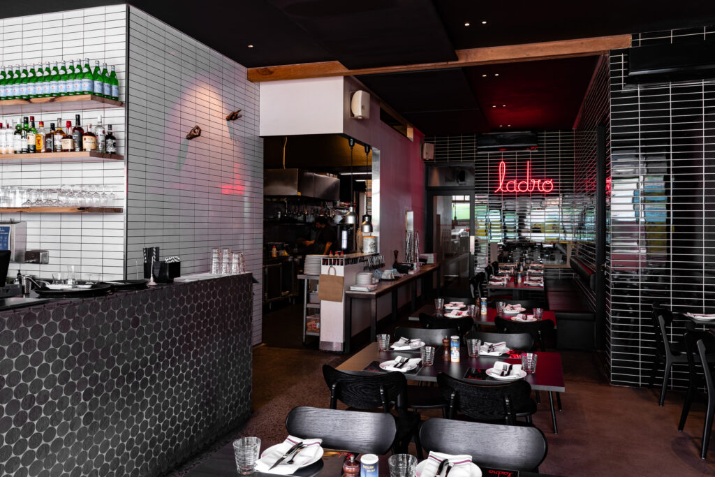 Modern restaurant interior with bar and dining tables.