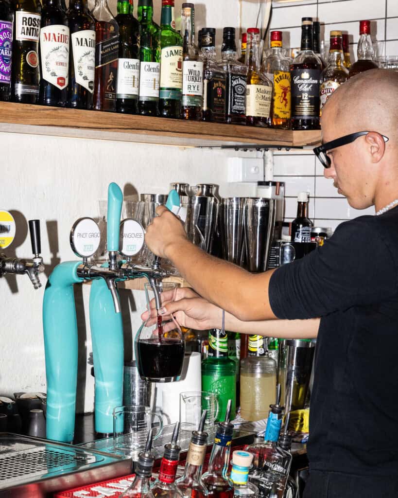 Bartender pouring drink at a busy bar.