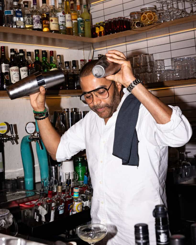 Bartender mixing drinks at a bar counter.