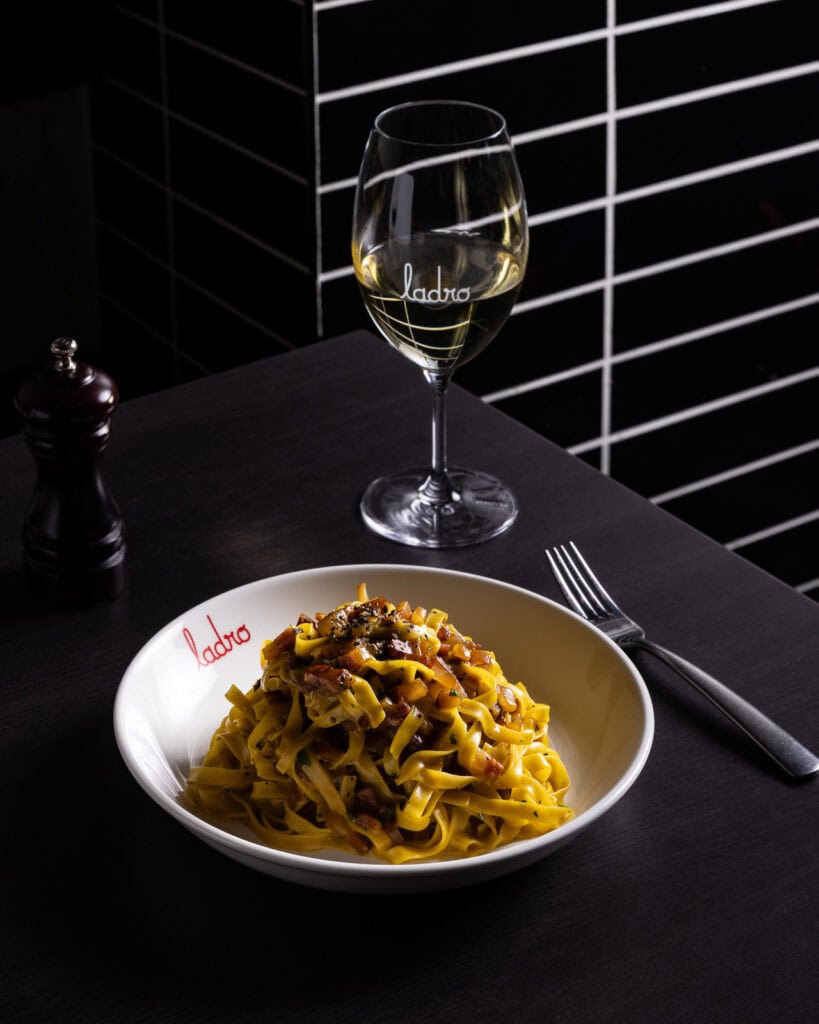 Tagliatelle pasta with white wine on table
